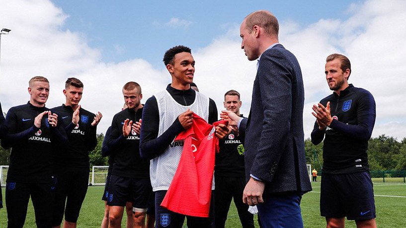 Prince William handing Trent Alexander-Arnold a jersey.